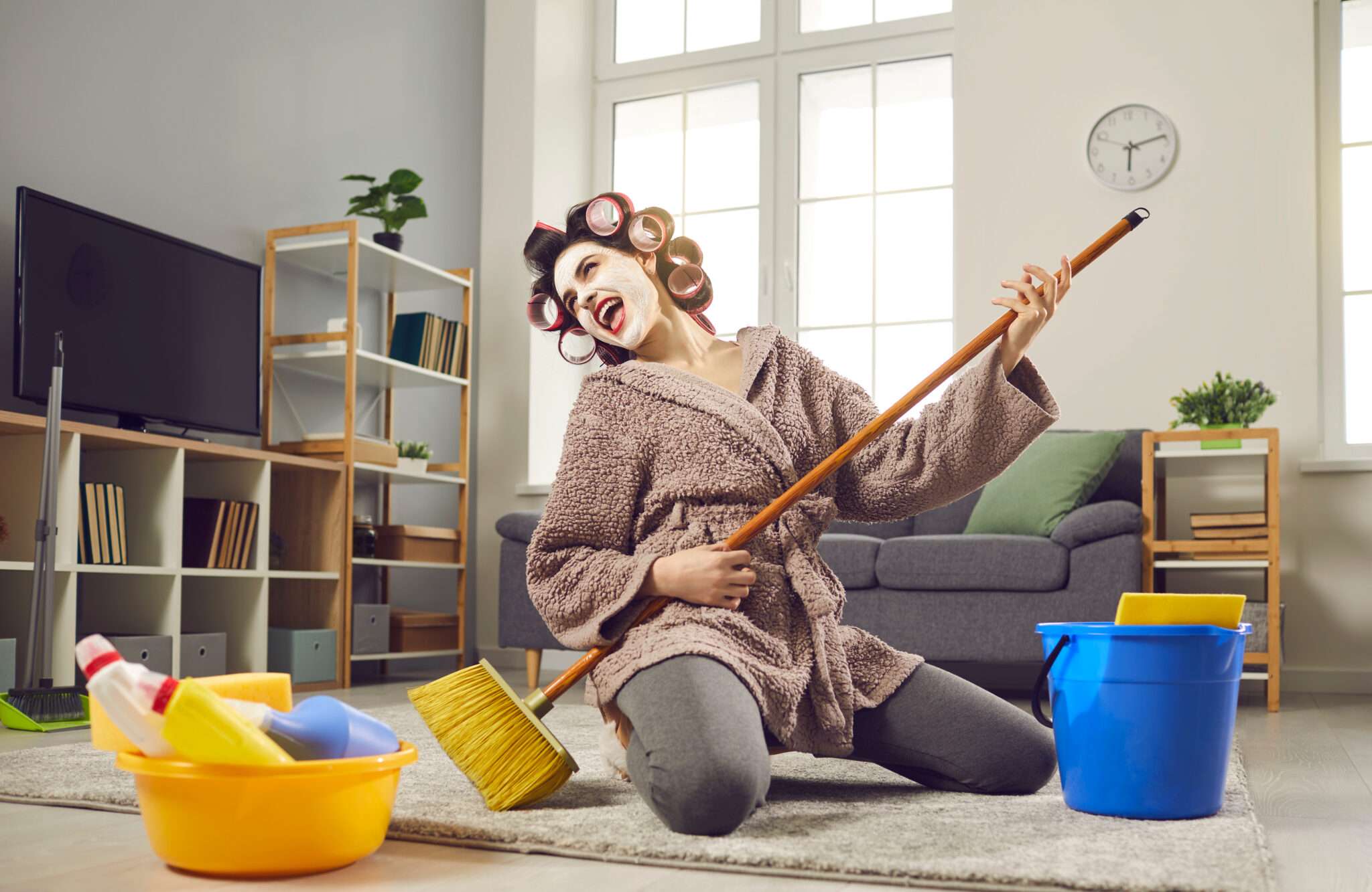 フランスのリビングルームをほうきで掃除する女性。