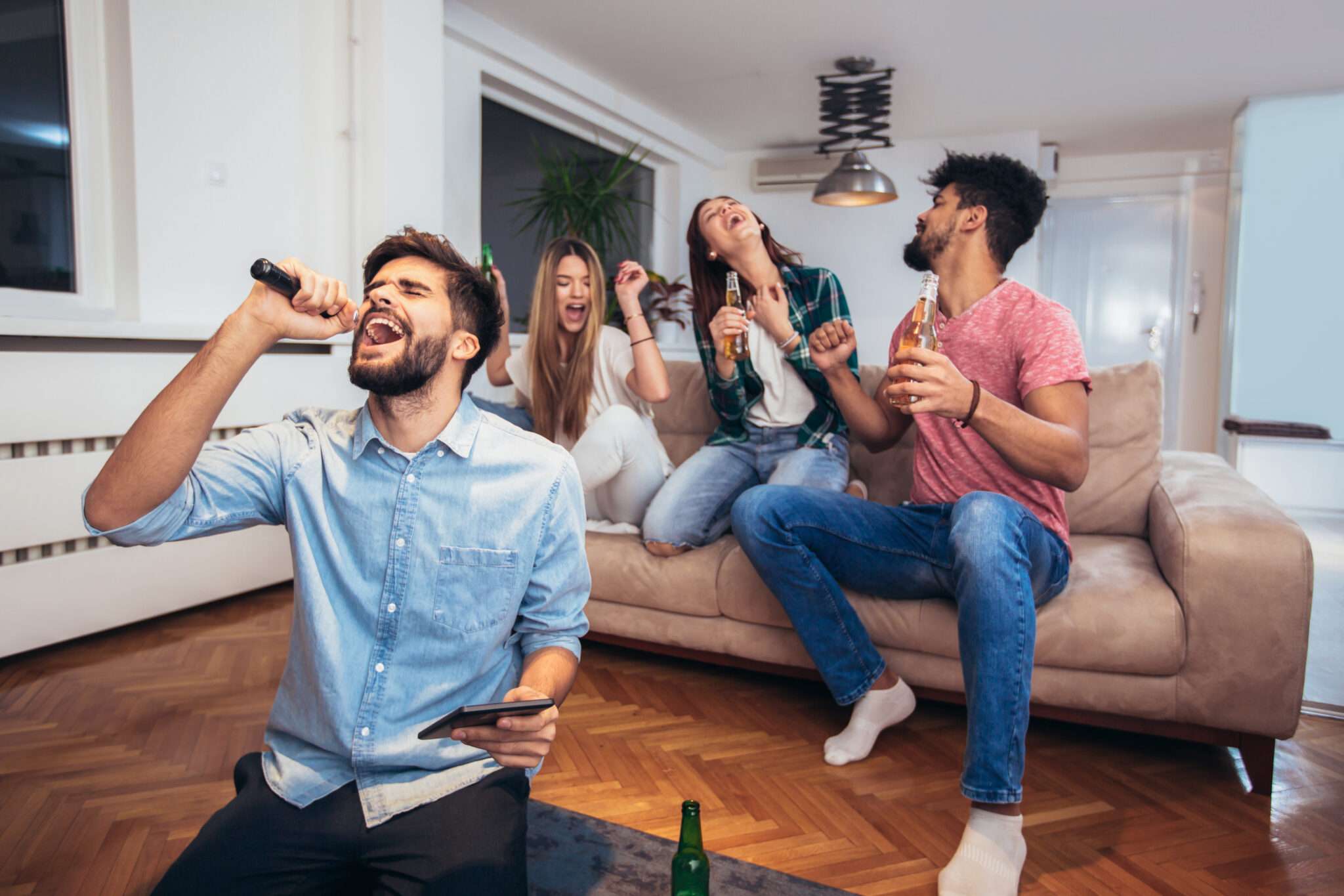 フランスのリビングルームで歌いながら酒を飲む人々のグループ。
