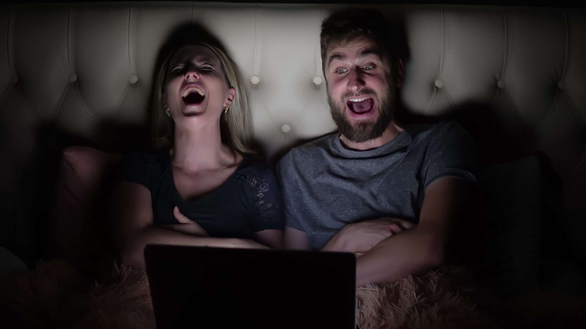 フランスでラップトップで映画を観ながら笑っているカップル。
