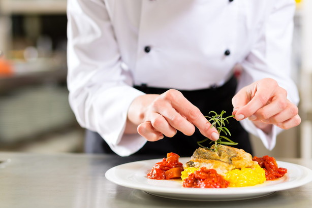 フランス人シェフが皿に料理を準備しています。
