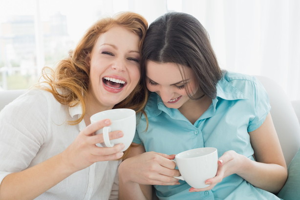 フランスの自宅でコーヒーを飲みながら笑っている 2 人の女性。