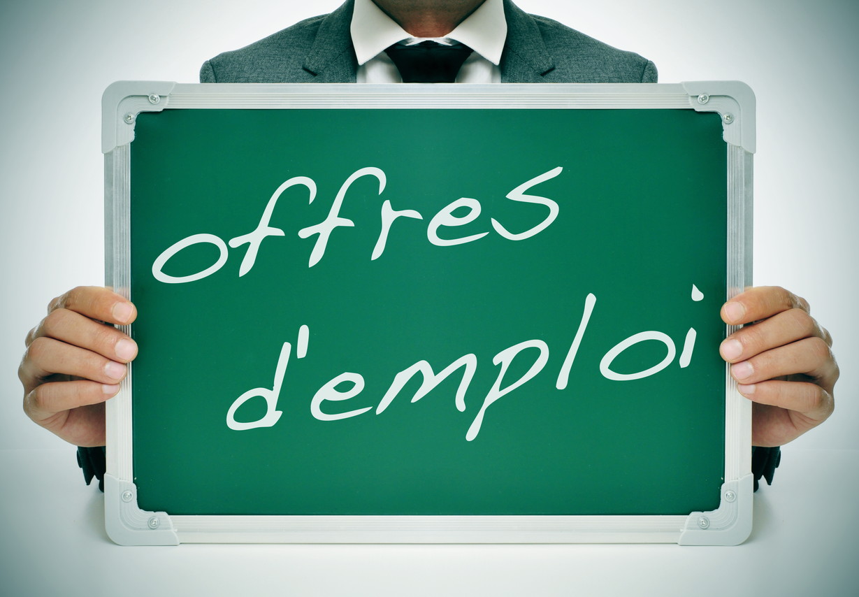 フランスの「offre des deploie」という言葉が書かれた黒板を掲げるビジネスマン。