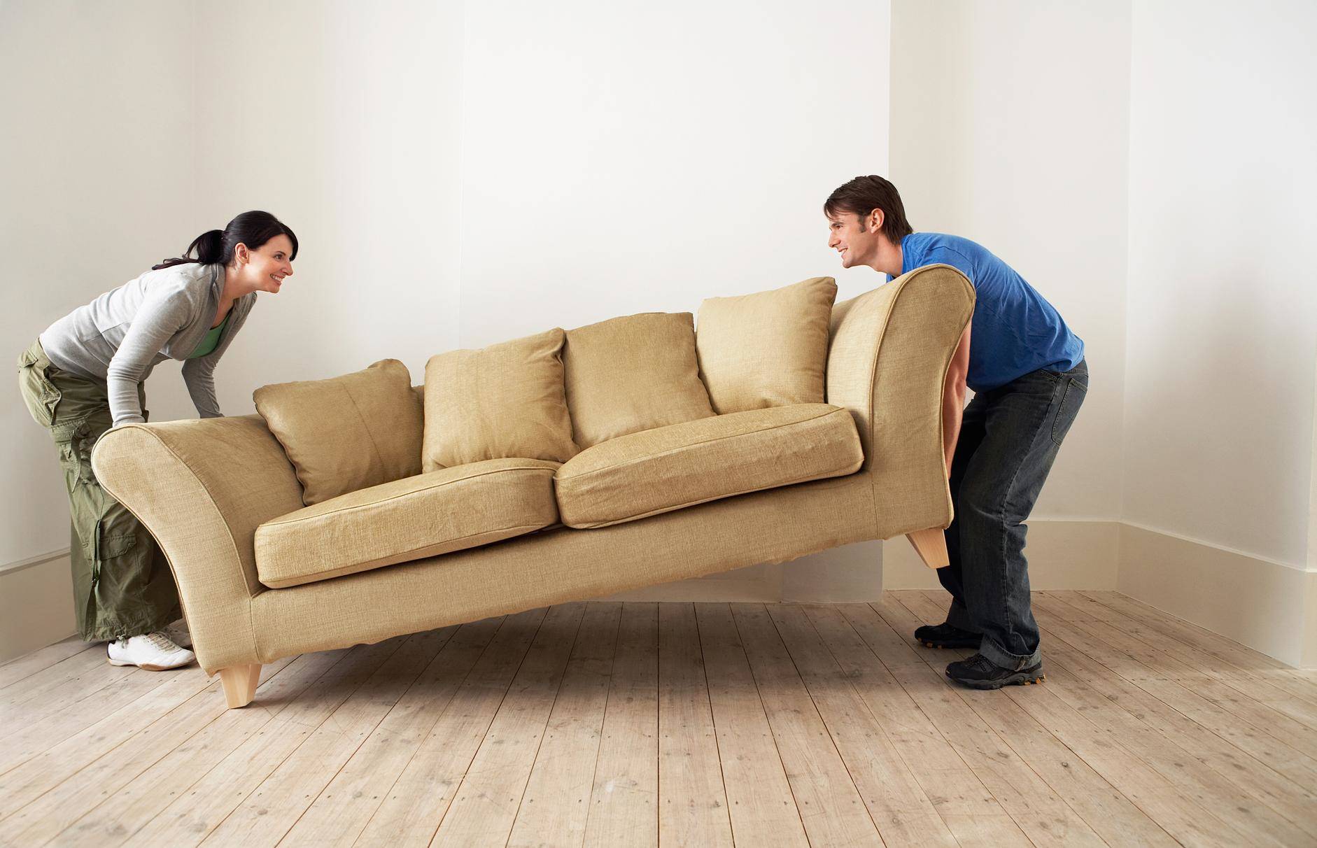 フランスの空き部屋でソファを移動する男性と女性。