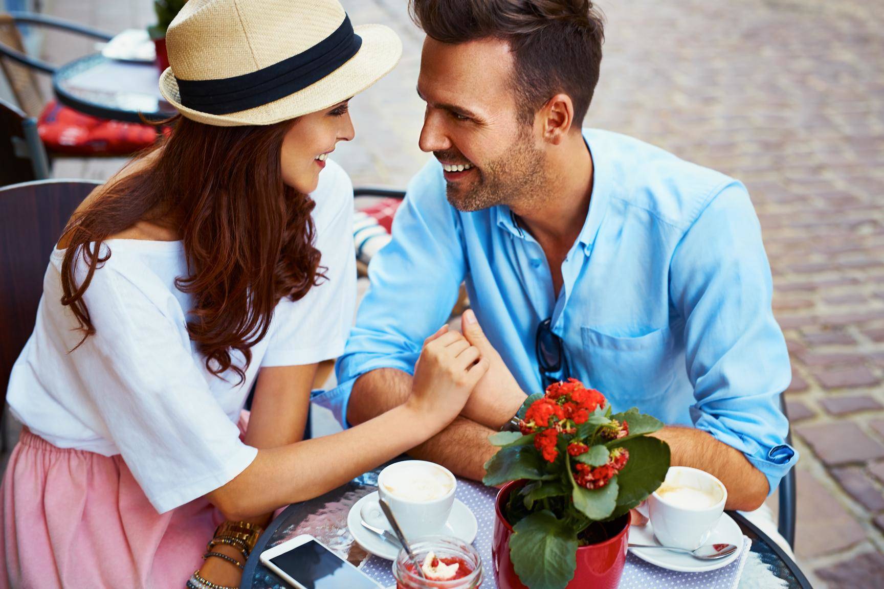 フランスの屋外カフェでコーヒーを楽しんでいる男性と女性。