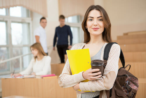 フランス語の教室でフォルダーを持っている若い女性。
