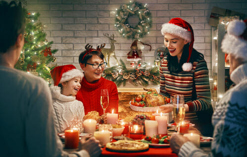 フランスでサンタクロースの帽子をかぶってクリスマスディナーを楽しむ家族。