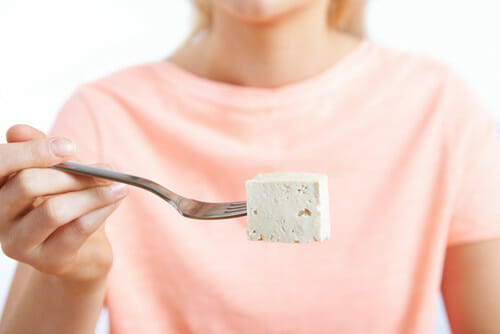 フランスで食事を楽しむ女性が、豆腐をフォークに丁寧につかんでいる。