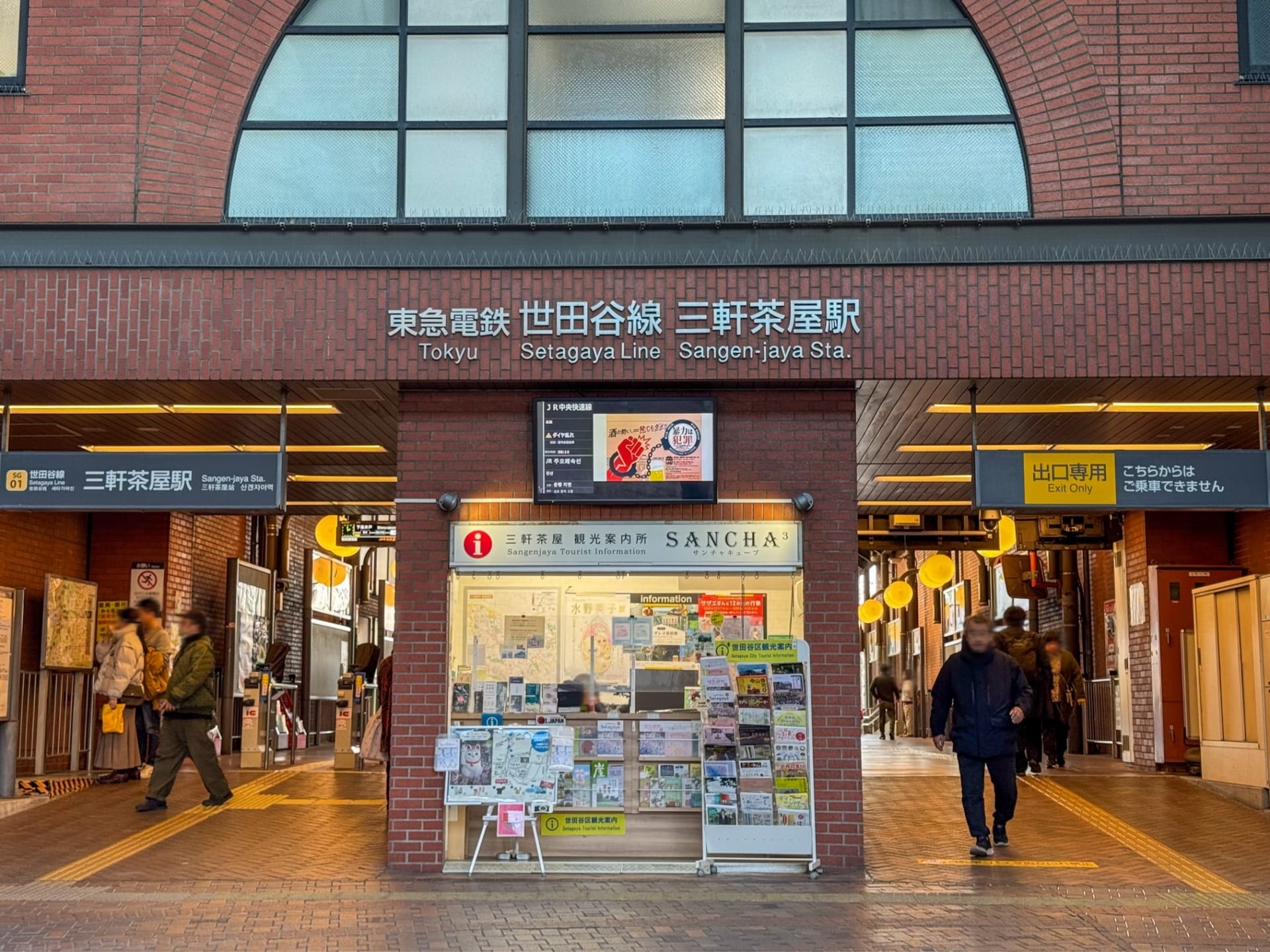 三軒茶屋駅の入口にはにぎやかな切符売り場があり、日本語と英語の看板の下を人々が歩いています。近くには、個人的なフランス語レッスンを求めている人向けのフランス語教室マンツーマンも見つかるかもしれません。.