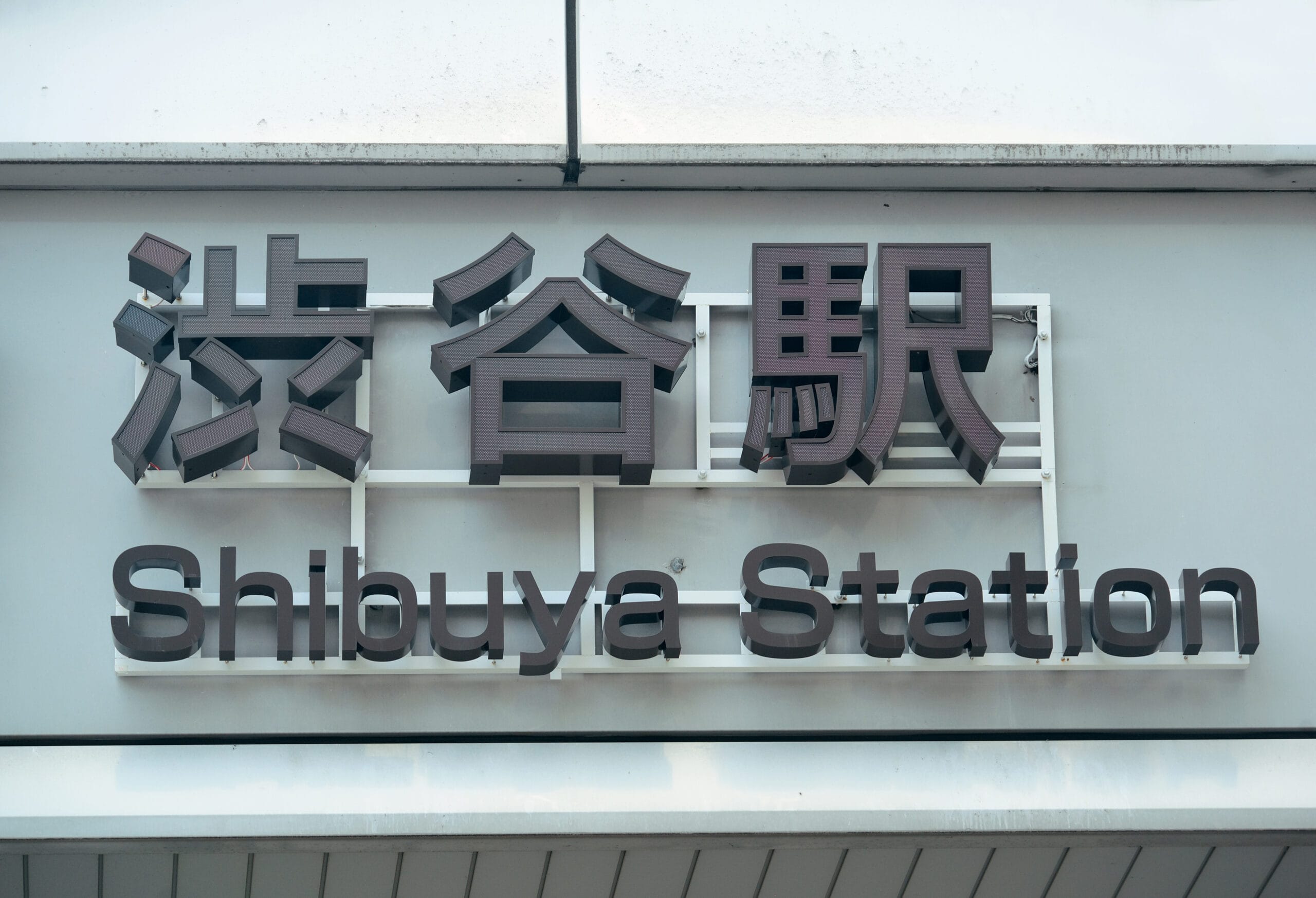 看板には英語と日本語の両方の文字で「渋谷駅」が優雅に表示されています。.