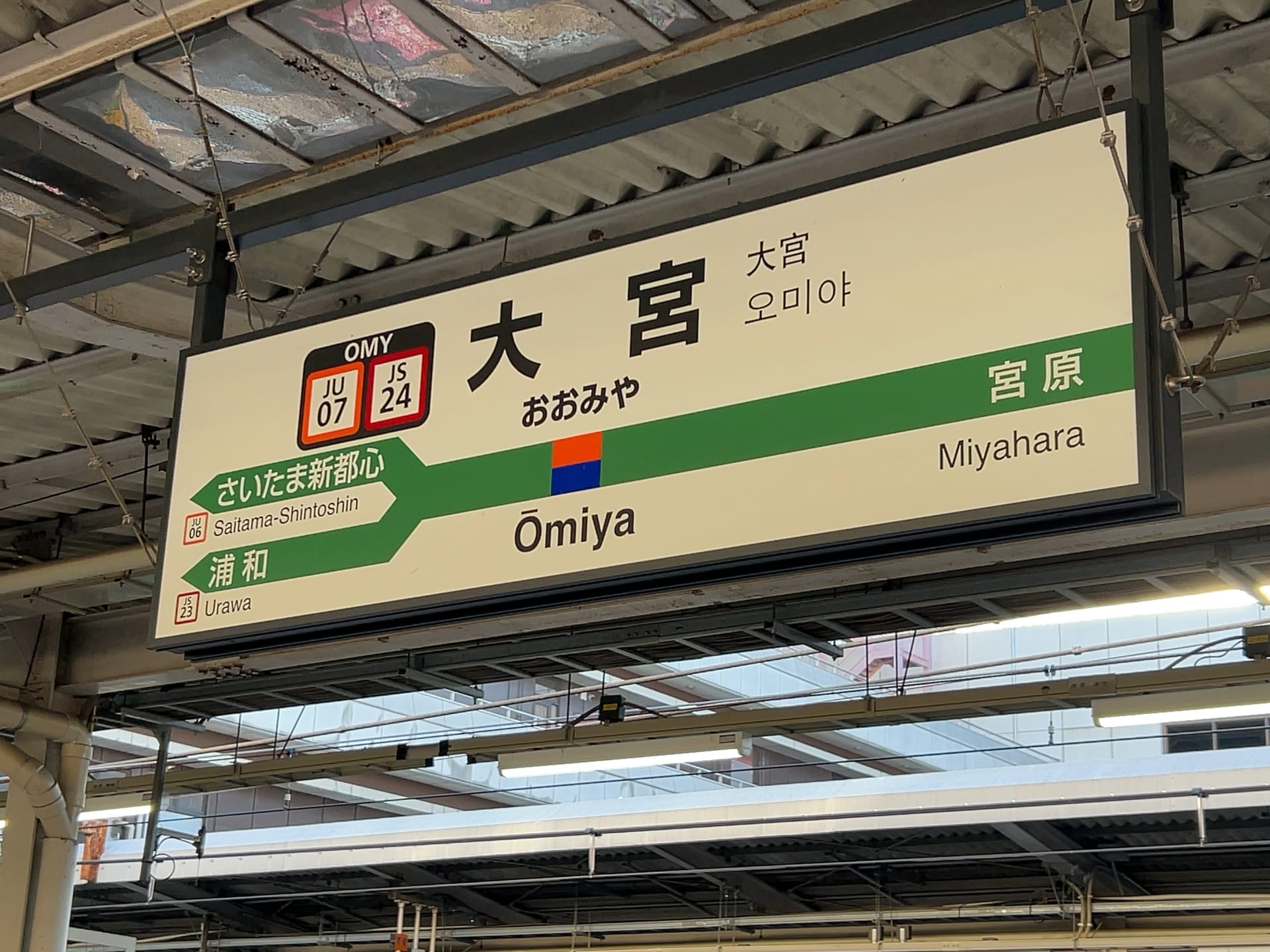 大宮駅の標識には、プラットフォームの詳細やさいたま新都心駅、宮原駅などの隣接駅が表示されており、日本語、英語、韓国語、さらには語学レッスンを求める旅行者のニーズに応えるためにフランス語でも案内されています。.